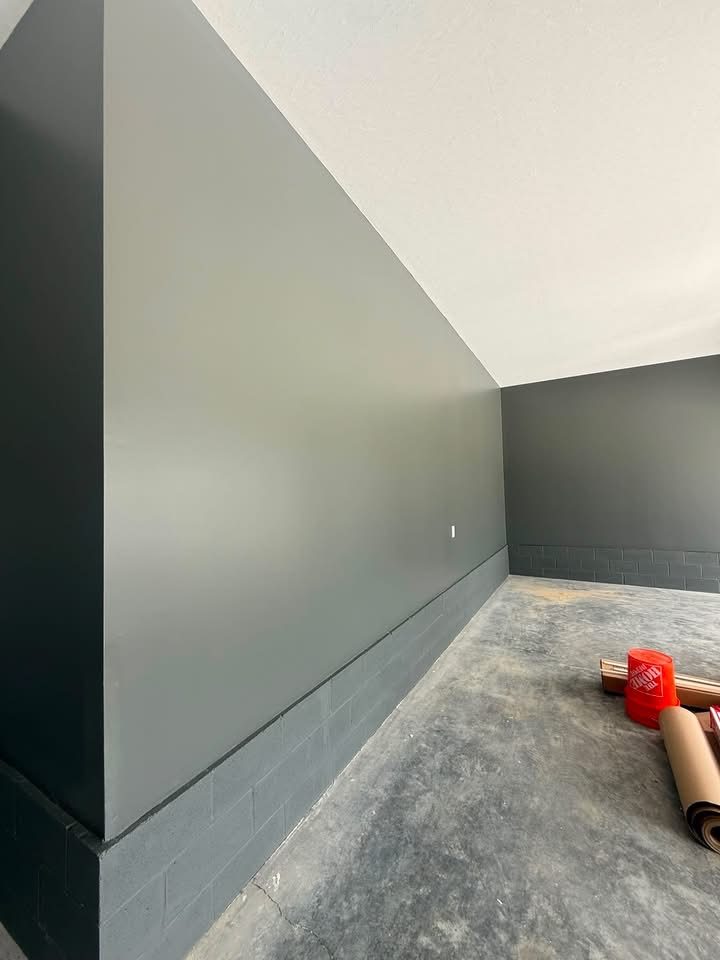 Freshly painted basement wall in a muted olive-gray tone
