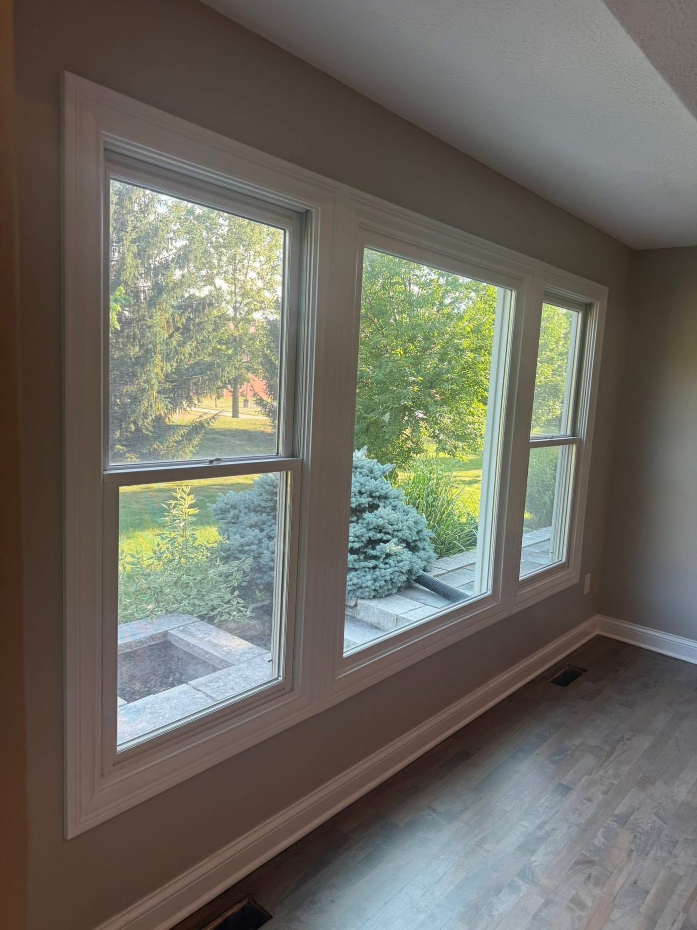 Completed interior room with freshly painted walls, white trim, and large windows