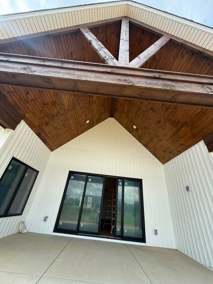 Freshly painted white exterior porch ceiling with finished wood beam accents
